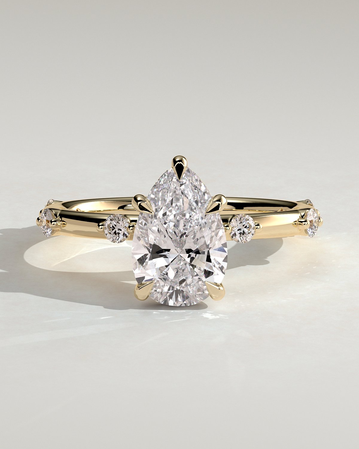 Amora - Pear Solitaire with Round Side Stones - 18k Yellow Gold