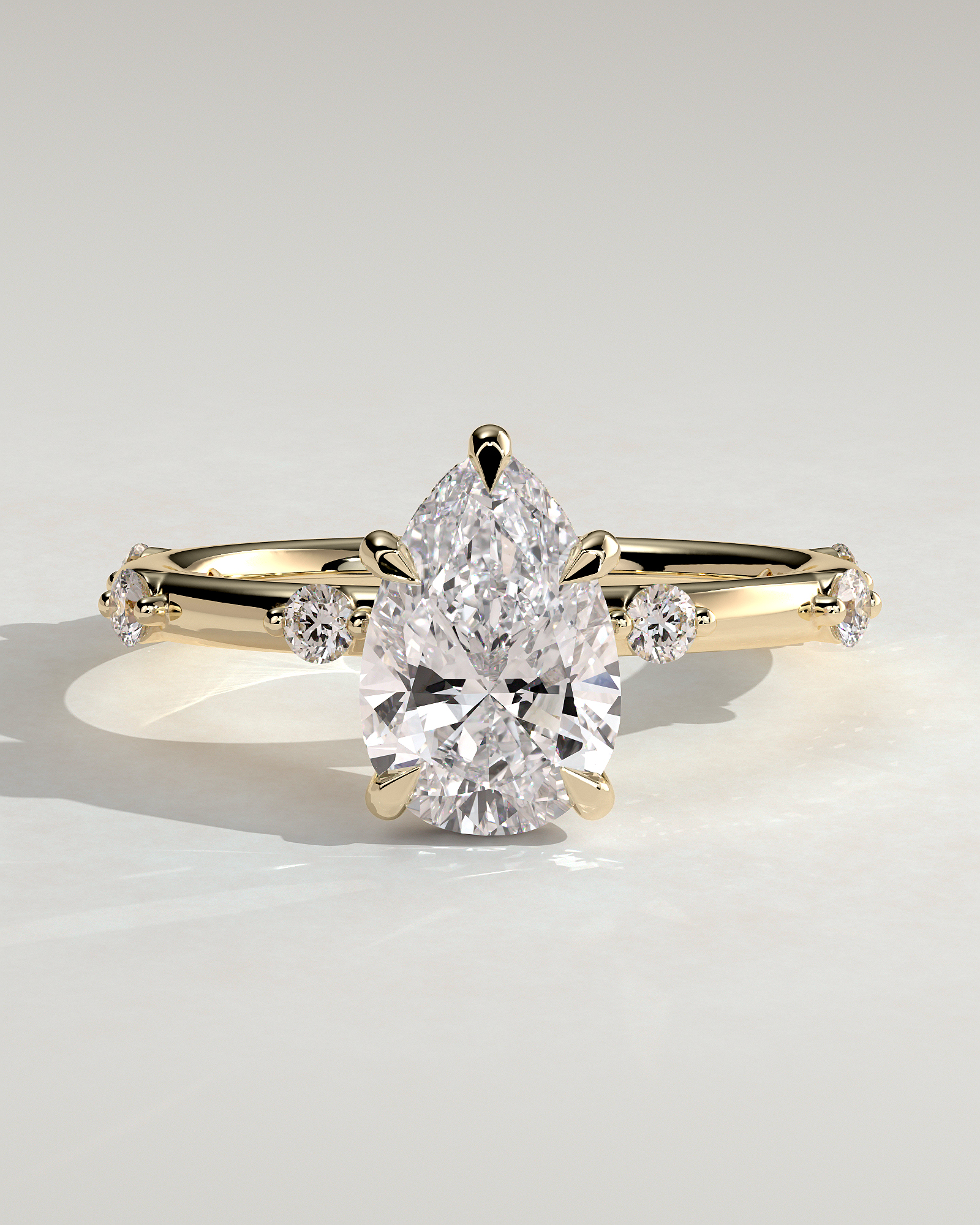 Amora - Pear Solitaire with Round Side Stones - 18k Yellow Gold