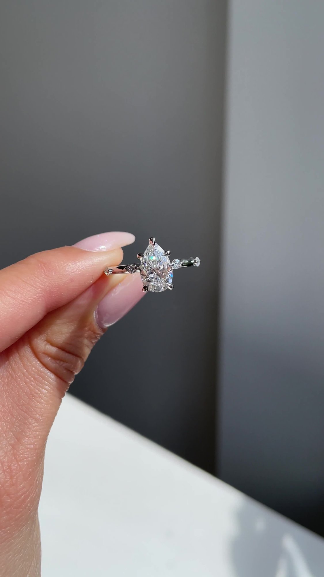 Amora - Pear Solitaire with Round Side Stones Lifestyle Image