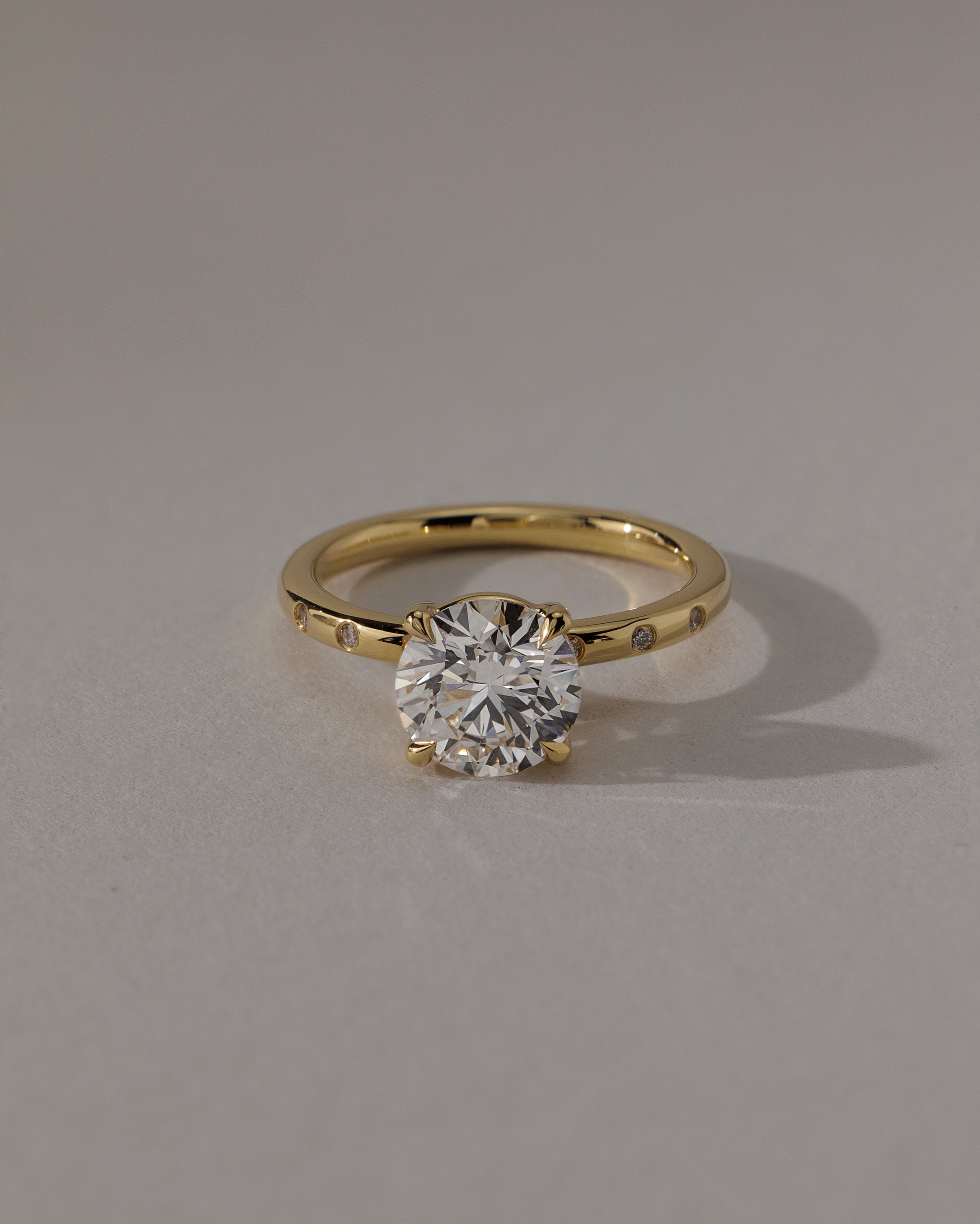 Nekija - 4 Claw Round Solitaire with Accent Stones Lifestyle Image