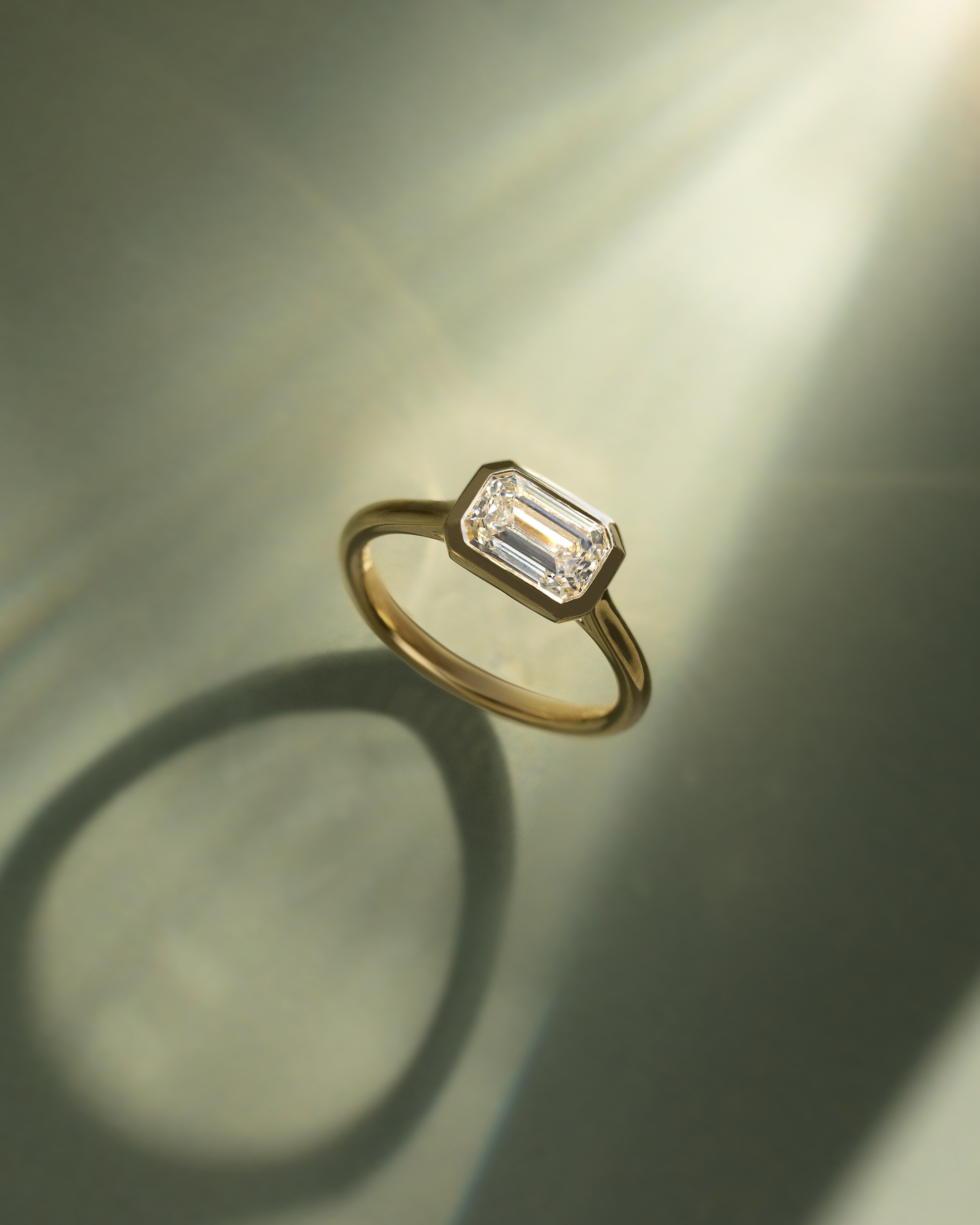 Olive - East West Emerald Solitaire with Cathedral Bezel Setting Lifestyle Image